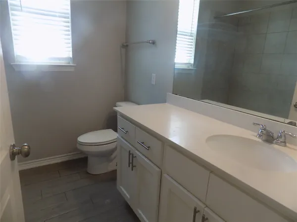 a bathroom with a sink a toilet and window