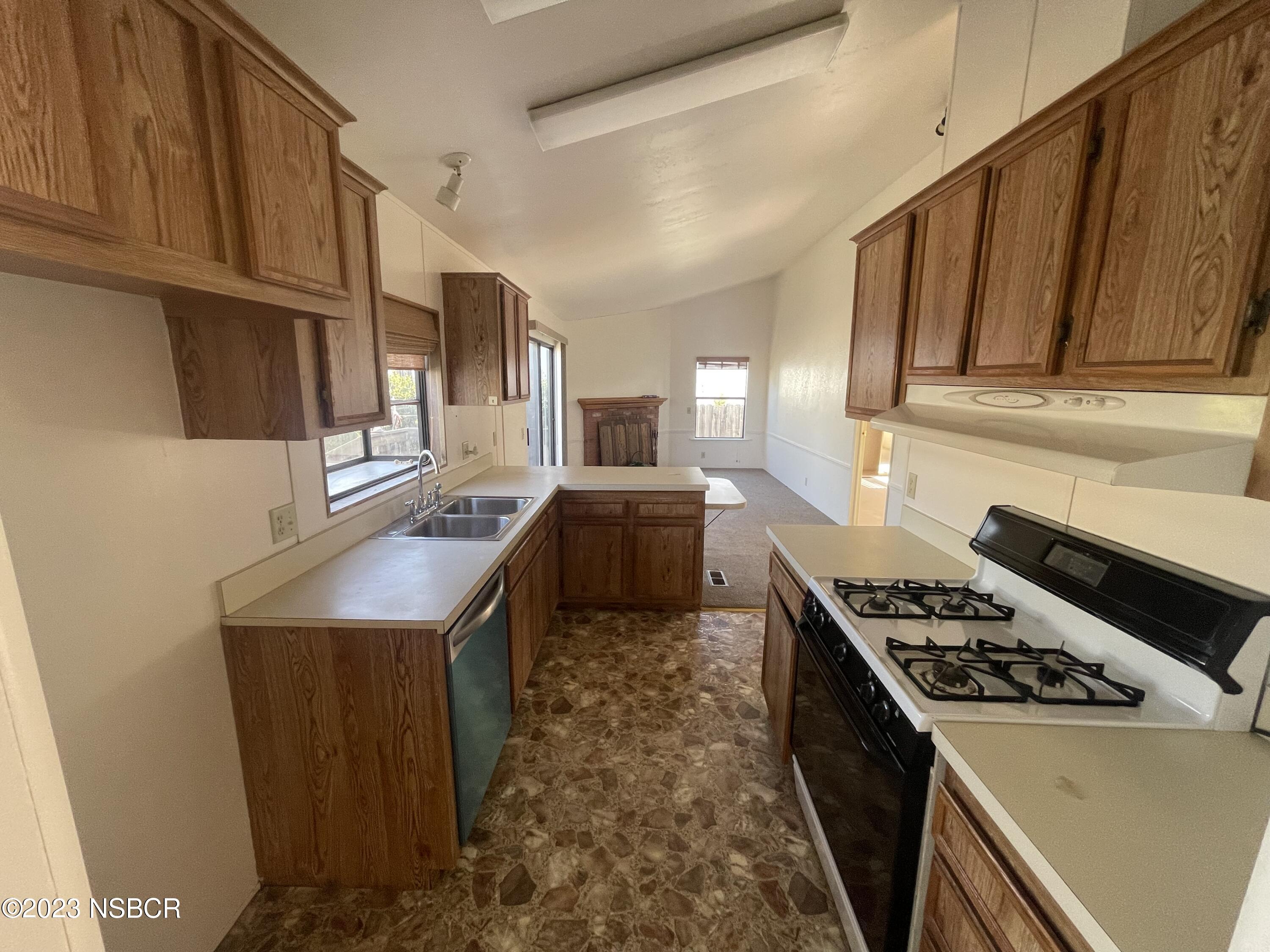 1317 V Street, Unit 114 Lompoc, CA 93436 - Photo 7 of 24 a kitchen with stainless steel appliances granite countertop a stove a sink and a refrigerator