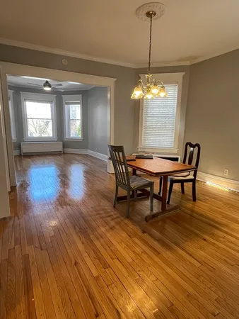 a dining room with furniture a chandelier and wooden floor