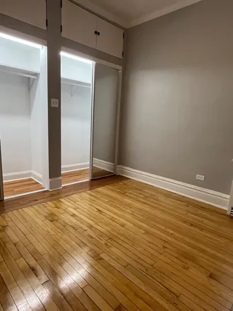 an empty room with wooden floor and closet