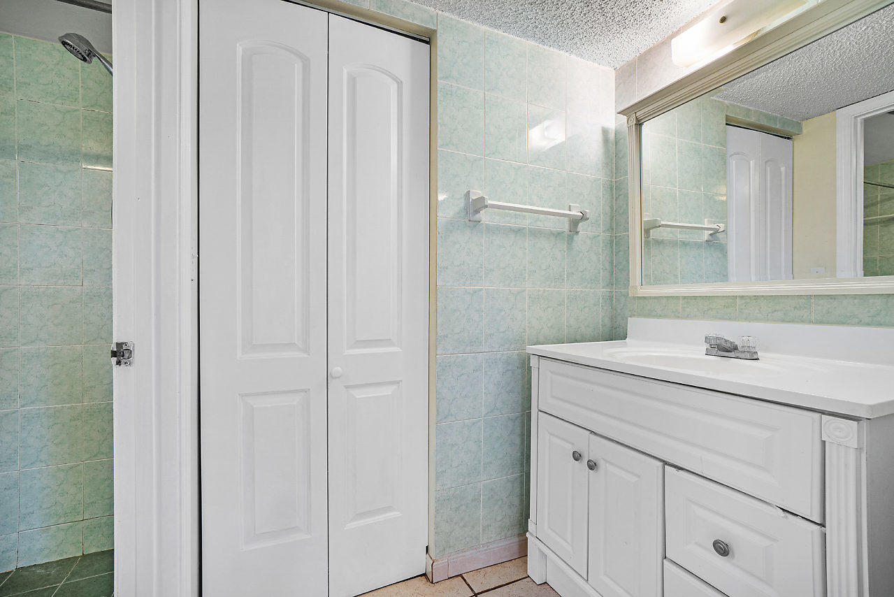 3050 Norwood Place, Unit N112 Boca Raton, FL 33431 - Photo 14 of 23 a bathroom with a sink and a mirror