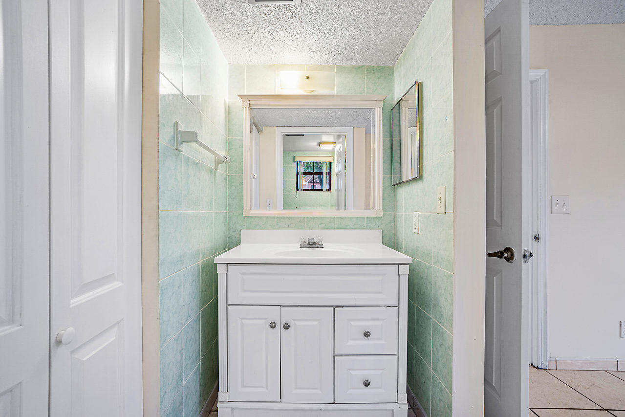 3050 Norwood Place, Unit N112 Boca Raton, FL 33431 - Photo 16 of 23 a bathroom with a sink vanity and a mirror