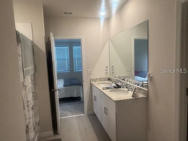 a en suite bathroom with a double vanity sink and a mirror