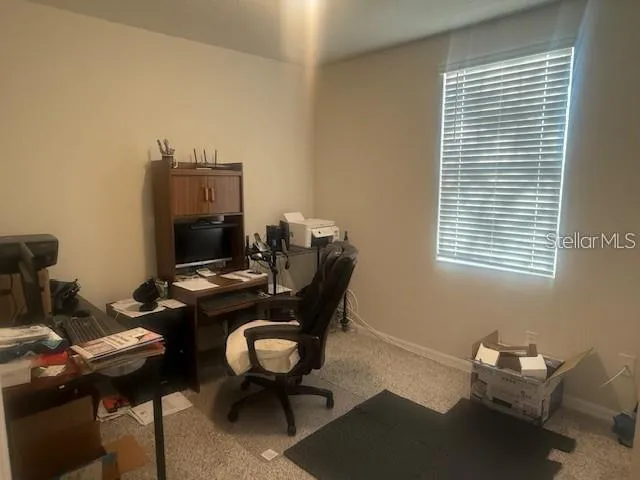 a view of a workspace with furniture and a window