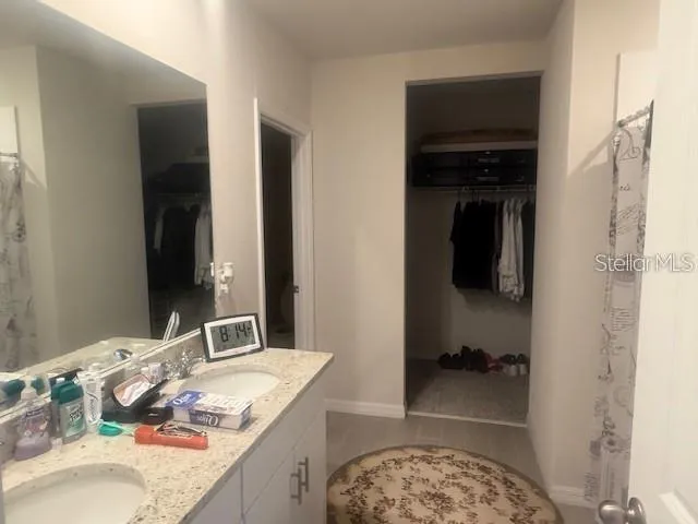 a bathroom with a granite countertop sink a mirror and shower