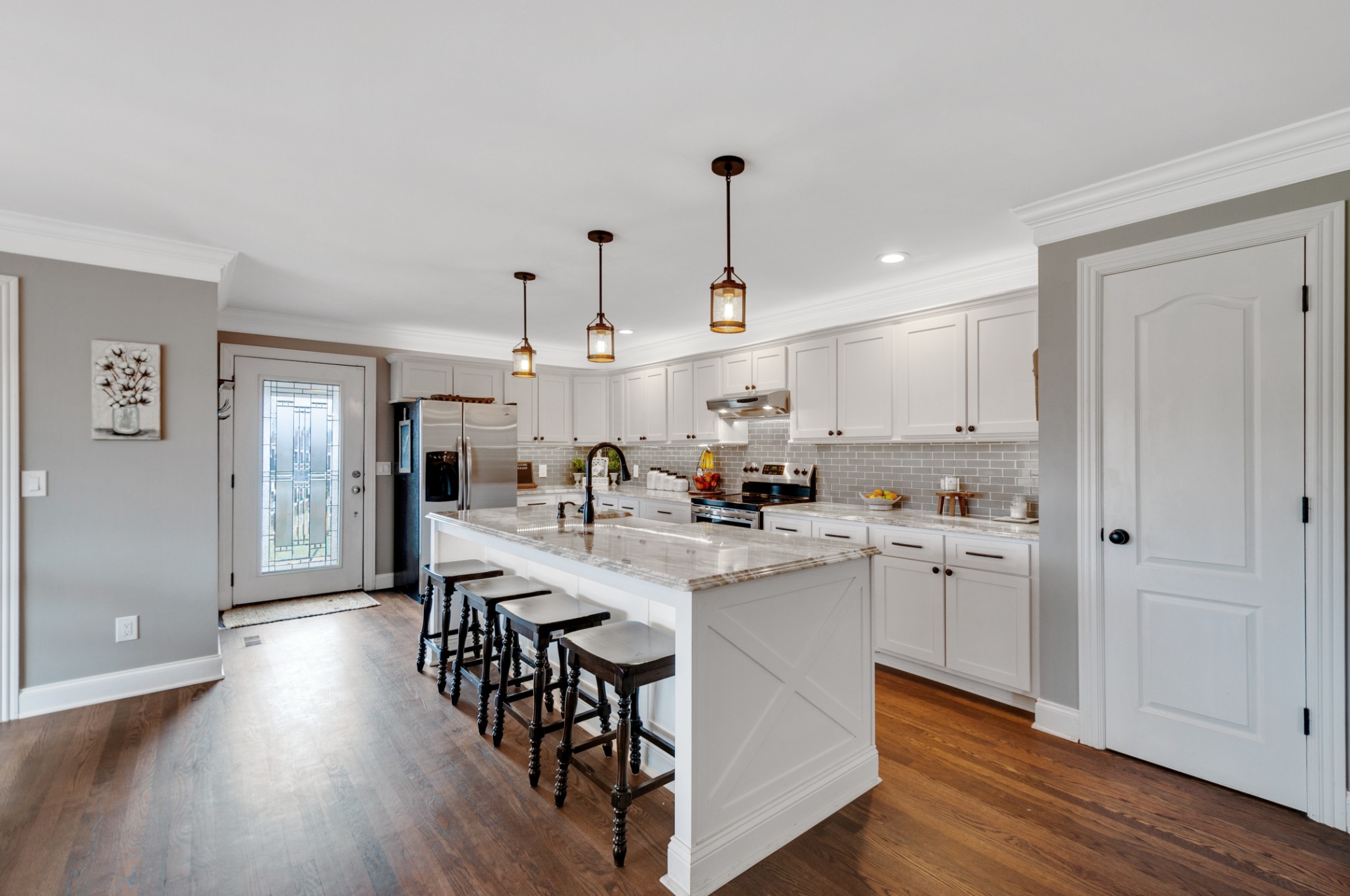 a large kitchen with kitchen island a white cabinets and stainless steel appliances