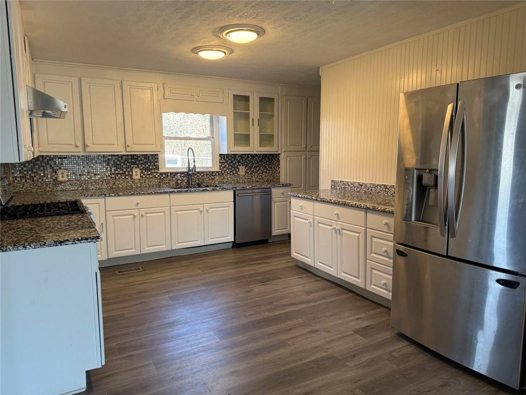 3383 Hamilton Mill Road Buford, GA 30519 - Photo 13 of 18 a kitchen with granite countertop a refrigerator and a stove top oven