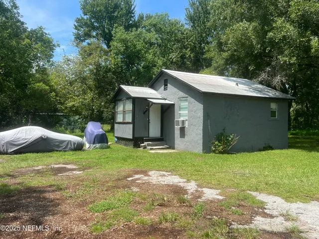 a view of a house with a yard and sitting area