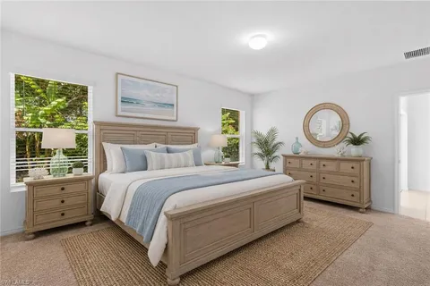 a bed room with a bed a mirror and a window