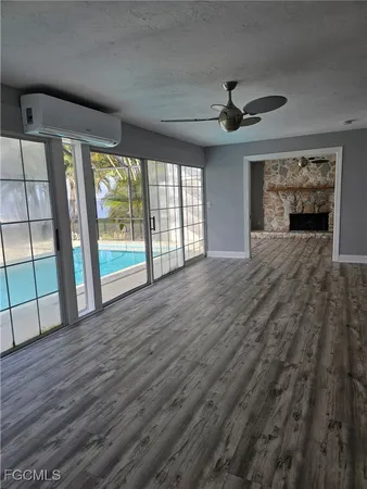a view of an empty room with a fireplace and a window