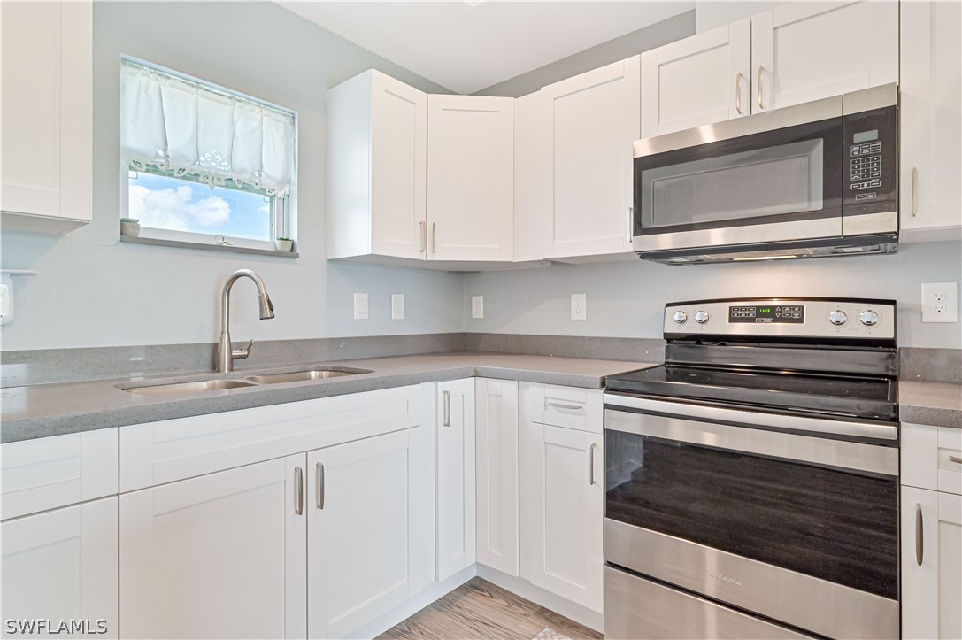 7085 Brazil Circle LaBelle, FL 33935 - Photo 15 of 32 a kitchen with granite countertop white cabinets and appliances