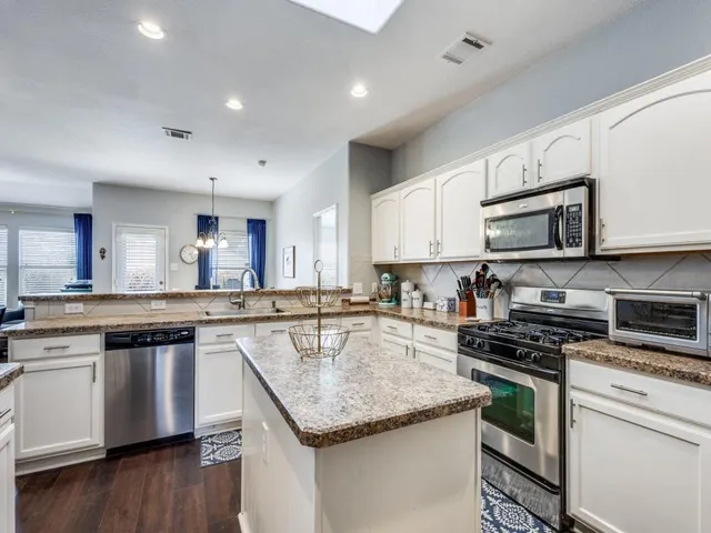 a kitchen with stainless steel appliances granite countertop a sink stove microwave and cabinets