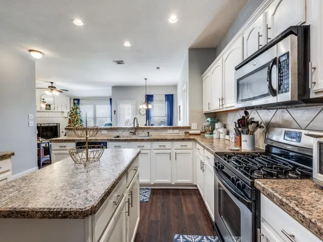 a kitchen with stainless steel appliances granite countertop a sink stove and cabinets