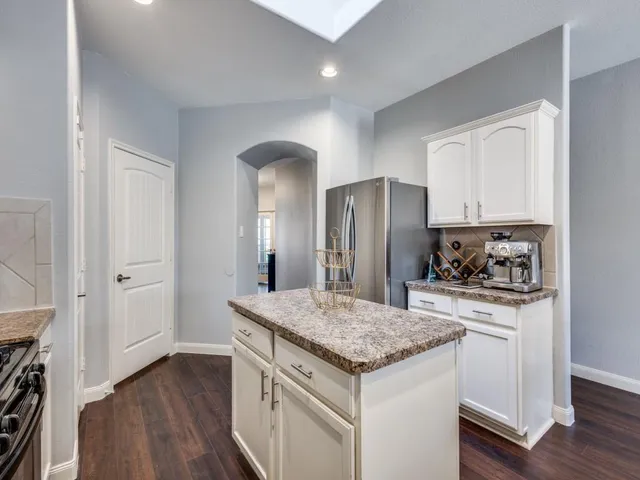 a kitchen with stainless steel appliances granite countertop a refrigerator and a stove top oven