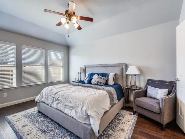 a bedroom with a large bed couch and a window