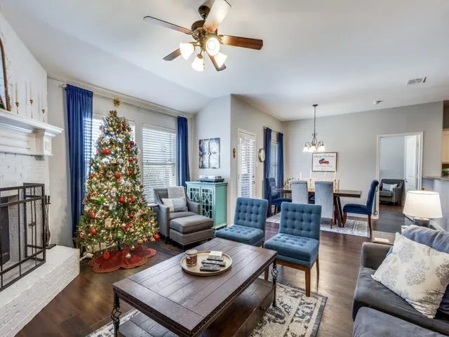 a living room with furniture flowers and a window