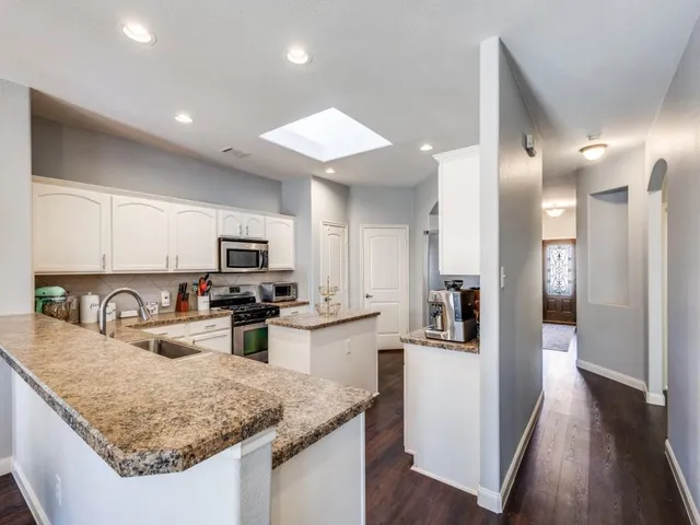 a kitchen with sink refrigerator and microwave