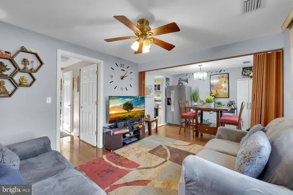 a living room with furniture and a flat screen tv with wooden floor