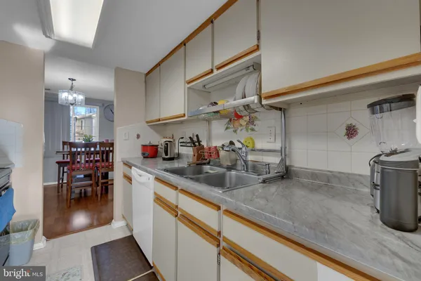 a kitchen with granite countertop a sink a stove and cabinets