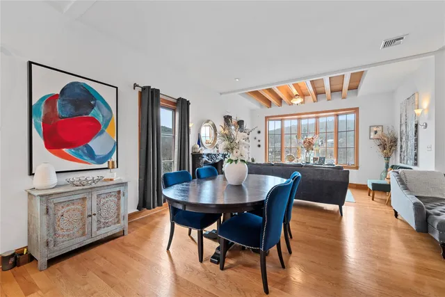 a view of a dining room with furniture wooden floor and a floor to ceiling window