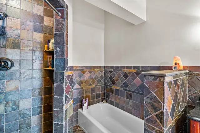 a bathroom with a bathtub and shower