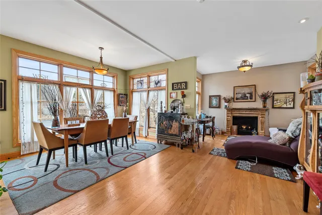 a living room with furniture a fireplace and large windows