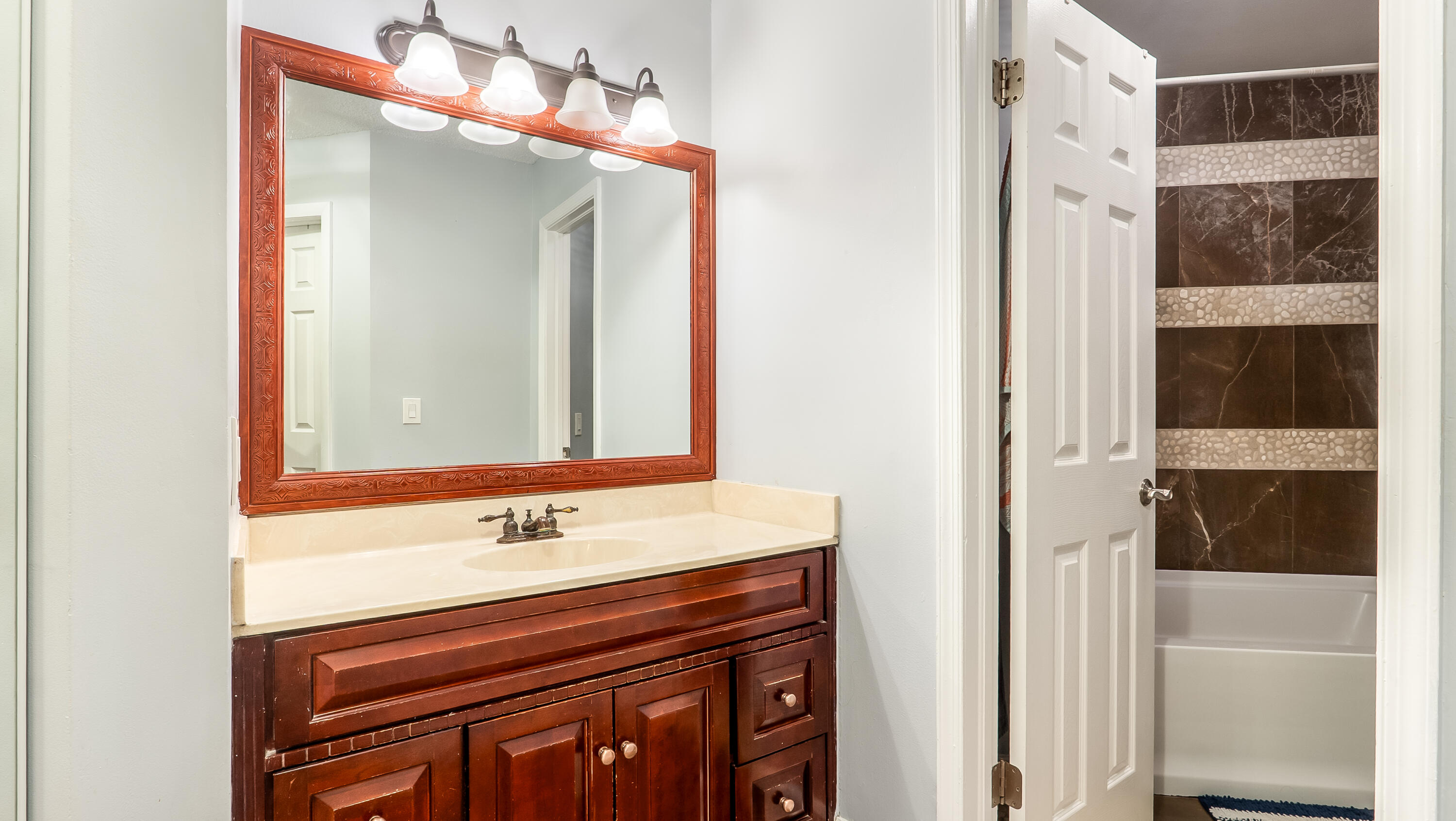 9358 Ketay Circle Boca Raton, FL 33428 - Photo 14 of 28 a bathroom with a sink a mirror and shower
