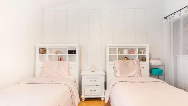 a bedroom with two beds and a large window