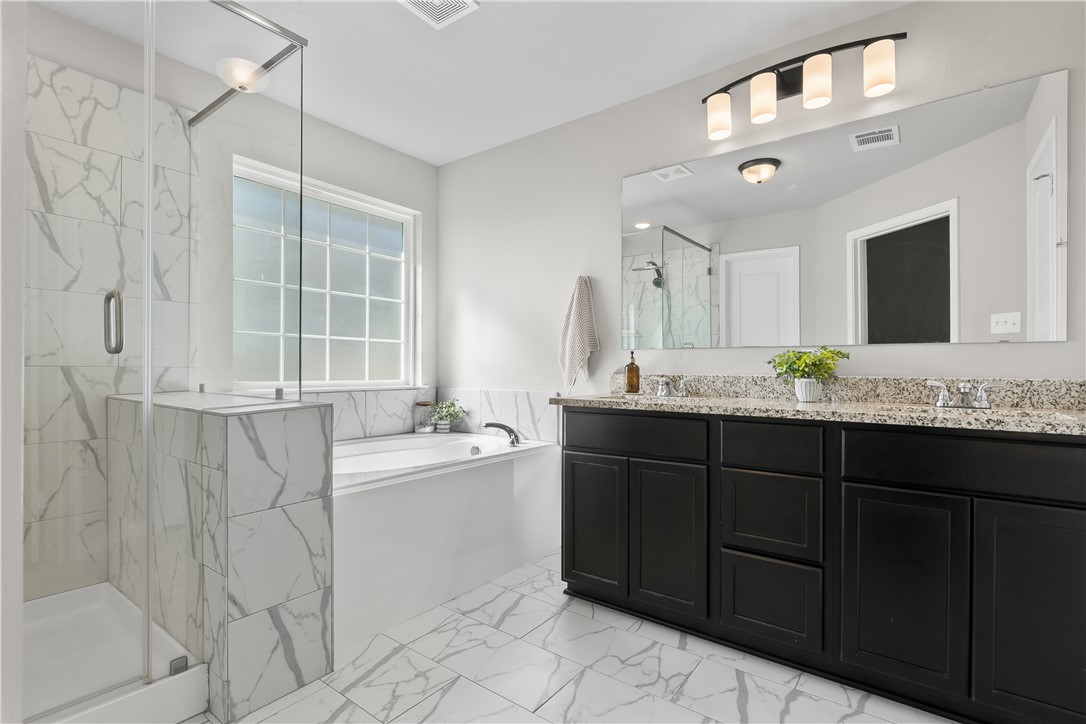 1925 Viva Road Bryan, TX 77807 - Photo 3 of 25 Full bathroom featuring double vanity, a marble finish shower, light marble finish floors, and a garden tub