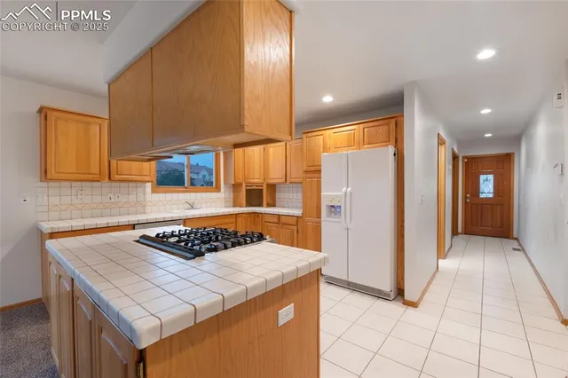 a kitchen with a sink a refrigerator and cabinets