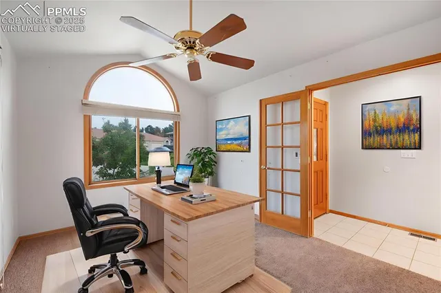 a view of a workspace with furniture and a window