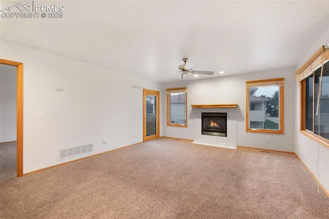 a view of an empty room with a fireplace and a window