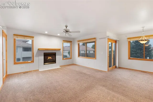 an empty room with windows and fireplace