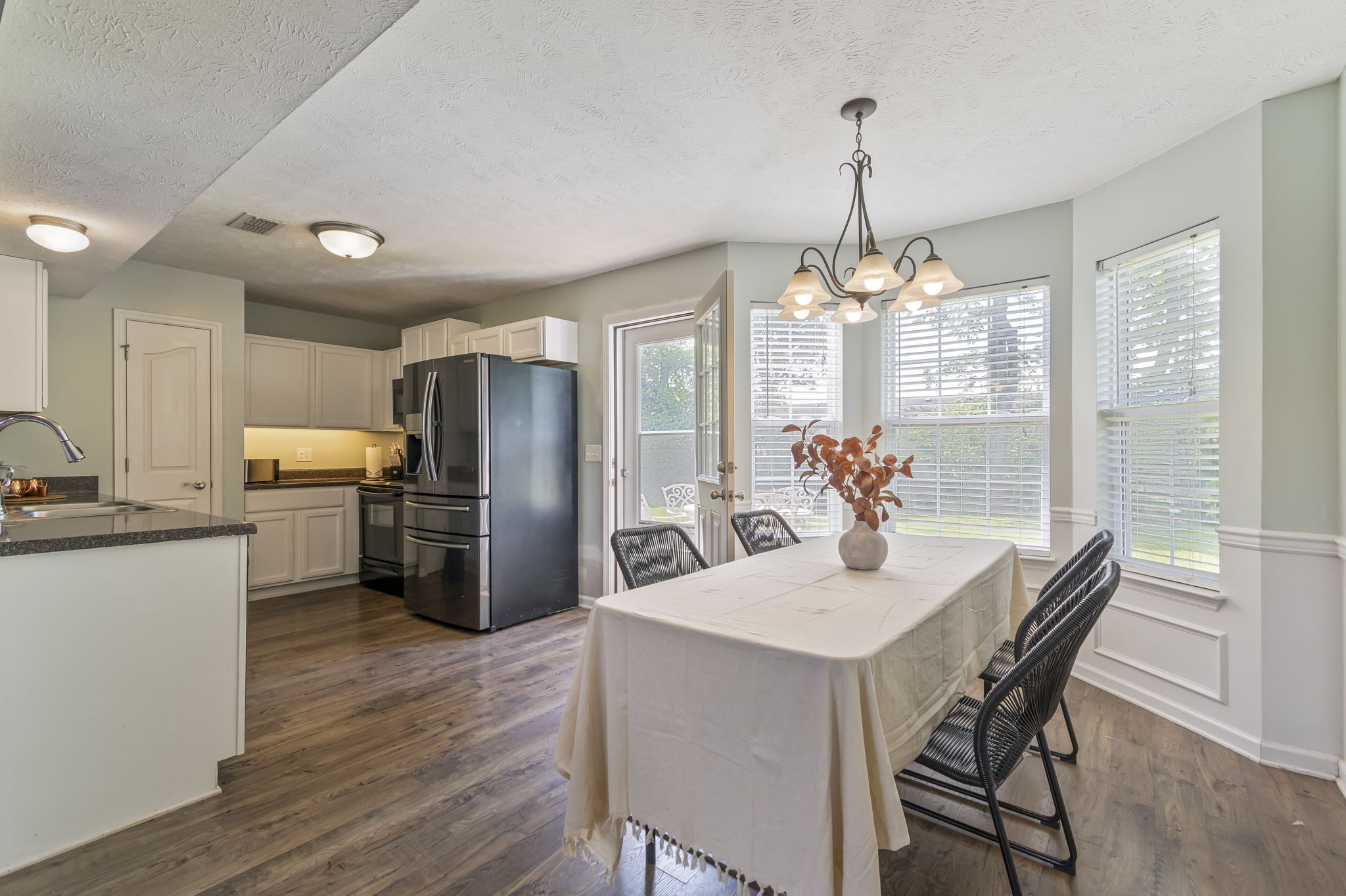 3317 Cornerstone Drive Murfreesboro, TN 37128 - Photo 12 of 33 a kitchen with a refrigerator a sink dishwasher a dining table and chairs with wooden floor