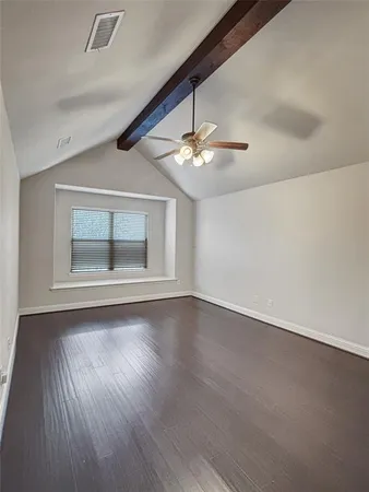 an empty room with wooden floor chandelier and windows