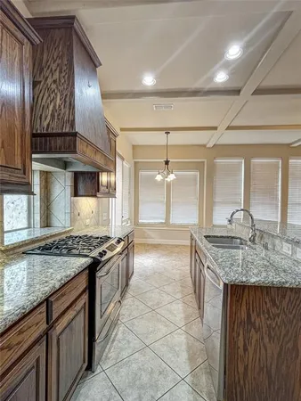 a kitchen with stainless steel appliances granite countertop a stove a sink and a microwave