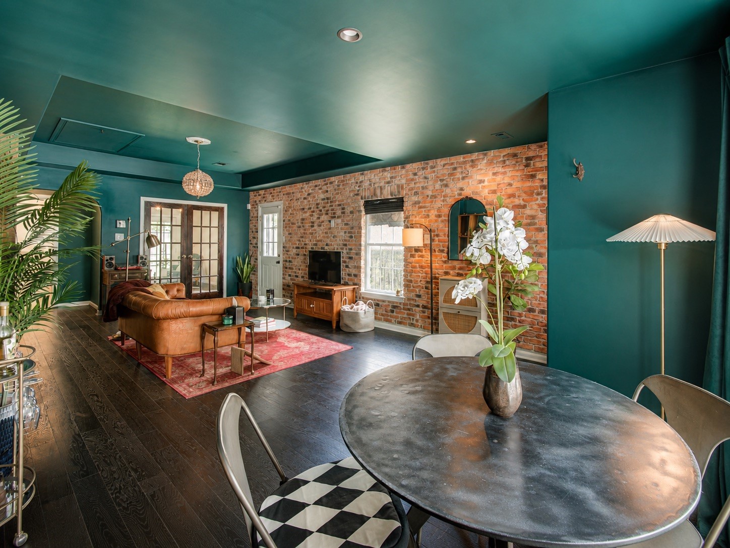 8647 Suburban Oaks Road Houston, TX 77093 - Photo 3 of 21 The dining area sits within the main living space, framed by dark floors and brick accent wall. (photo has been enhanced for marketing purposes)
