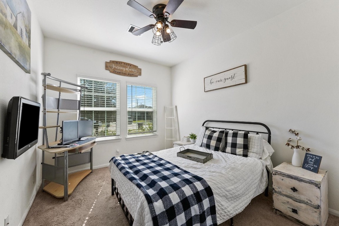 5303 Rivers Edge Drive Richmond, TX 77469 - Photo 14 of 26 a bedroom with a bed a dresser and a chandelier