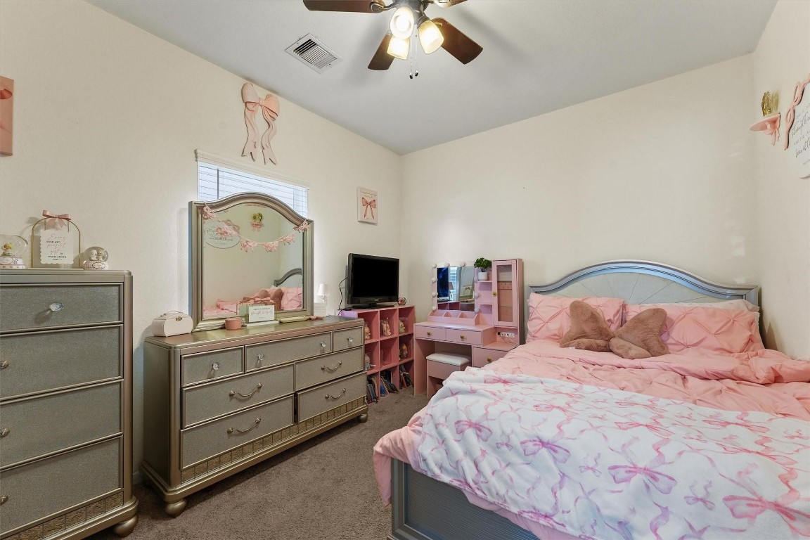 5303 Rivers Edge Drive Richmond, TX 77469 - Photo 15 of 26 a bedroom with a bed and a chandelier