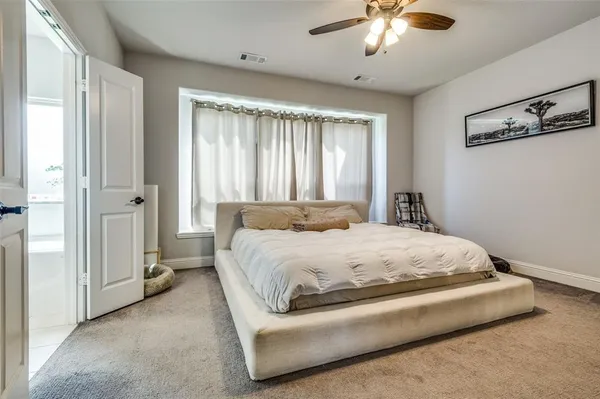 a spacious bedroom with a bed and a chandelier