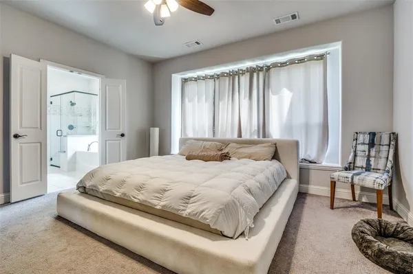 a spacious bedroom with a bed and a chandelier