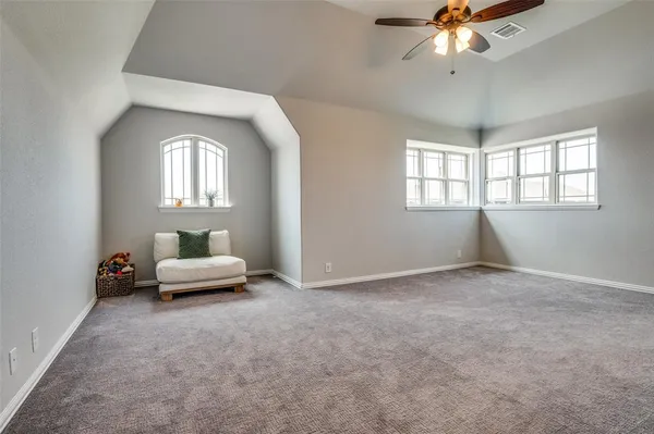 an empty room with windows and ceiling fan