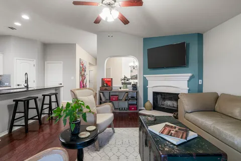 a living room with furniture a flat screen tv and a fireplace
