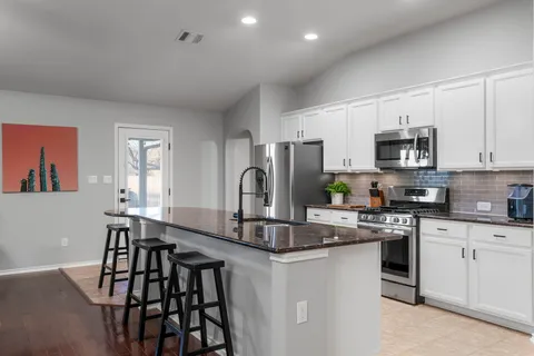 a kitchen with stainless steel appliances granite countertop a sink stove and cabinets