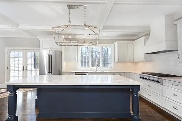 a kitchen with granite countertop a stove and a white cabinets