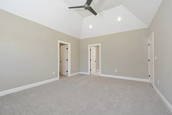 an empty room with ceiling fan and window