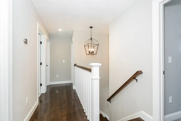 a view of a hallway with wooden floor and staircase