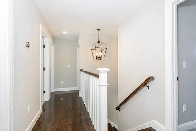 a view of a hallway with wooden floor and staircase