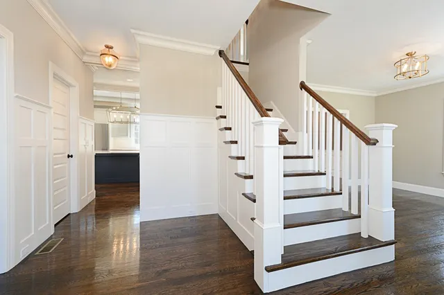 a view of a hallway with wooden floor and staircase