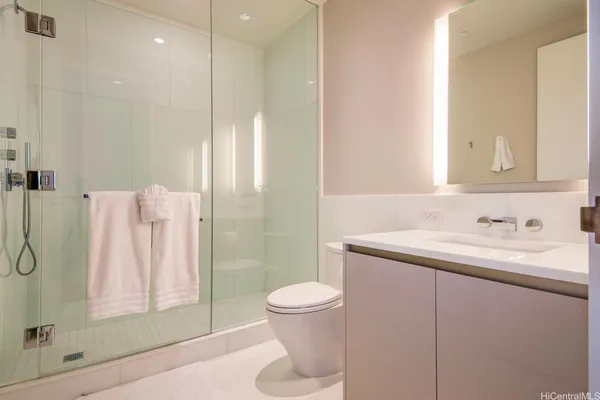 a bathroom with a granite countertop sink a toilet and shower